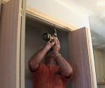 Man with cordless drill Installing track for bifold closet doors.