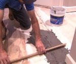 Using floor patching compound to level a subfloor.