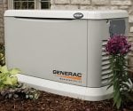 Generac standby generator in yard next to house.
