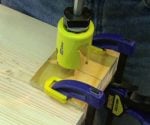 Drilling hole with plywood scraps clamped to stock