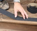 Applying a self-adhesive strips to an exterior wood step.