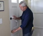 Danny Lipford lubricating a door lock.