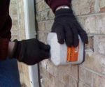 Installing an insulated foam hose bib cover on an outdoor spigot.