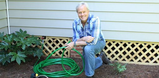 Danny Lipford in yard with hose.